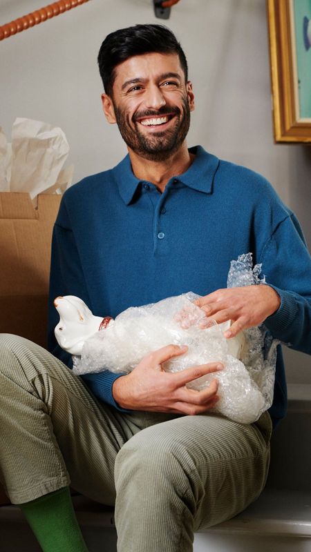 En person sittandes i en trappa som packar upp flyttkartonger