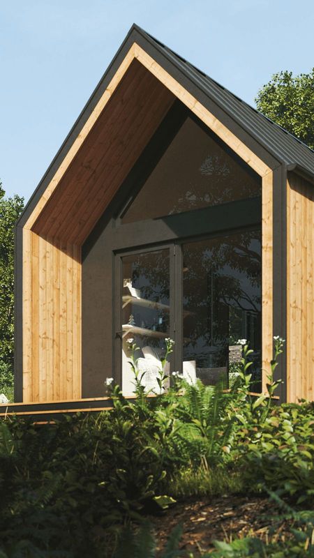 Modern trästuga tittar fram ur en tät skog