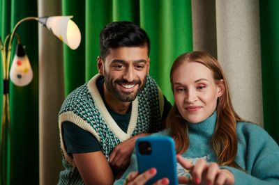Två personer som tittar på en telefon tillsammans